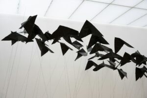Sculpture mobile noire composée de formes suspendues par des fils