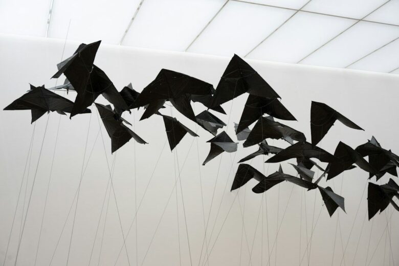 Sculpture mobile noire composée de formes suspendues par des fils